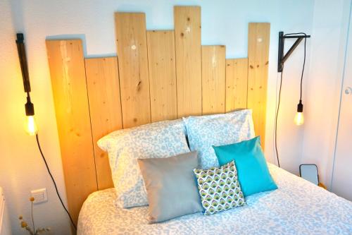 a bedroom with a bed with a wooden headboard at Djiiméé, Piscine & vue apaisante sur Golf, 5 pers in Talmont