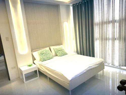 a small bedroom with a bed and a window at Berchby Loft in Digos