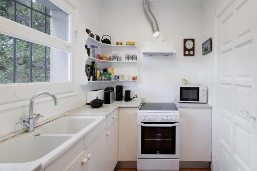 a white kitchen with a sink and a stove at Puigvermell in Pals