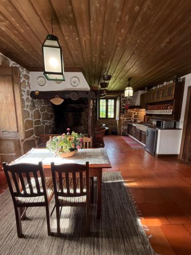 a dining room with a table and a stone fireplace at Casa Da Quinta Do Rei in Ponte de Lima
