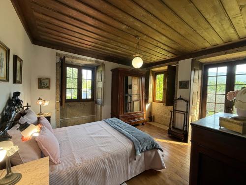 a bedroom with a large bed in a room with windows at Casa Da Quinta Do Rei in Ponte de Lima
