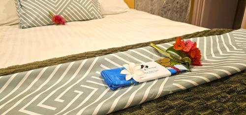 a bed with a tray with flowers on it at Vinita Villas in Ngatangiia