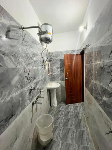 a bathroom with a toilet and a sink and a light at Kedar Mount View in Sonprayag