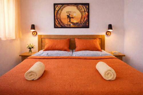 a bedroom with a large orange bed with towels on it at Apartmány Lipno-Hory in Horní Planá
