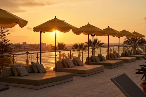 a row of tables with pillows and umbrellas on a resort at Hotel Riviera Costa del Sol - Adults Recommended in Benalmádena