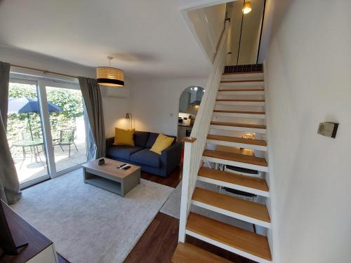 a staircase in a living room with a blue couch at 2 beds, AC, fully enclosed patio, private parking in Poole