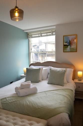 a bedroom with a large bed with towels on it at Royal Six Apartments in Harrogate