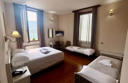 ein Hotelzimmer mit zwei Betten und zwei Fenstern in der Unterkunft Hotel Sebino in Sarnico