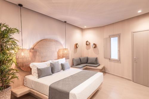 a bedroom with a bed and a chair and a window at EvMariA suites in Fira