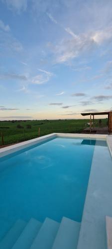 a large blue swimming pool with a gazebo at Monte do Arneiro in Sousel