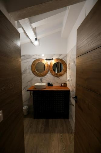 a bathroom with a sink and two mirrors on the wall at Hostal Rural Sartaguda in Sartaguda
