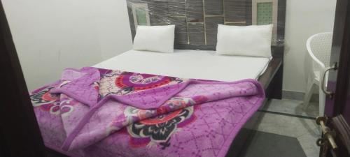a small bedroom with a bed with a purple blanket at Hotel Paradise in Chandīgarh
