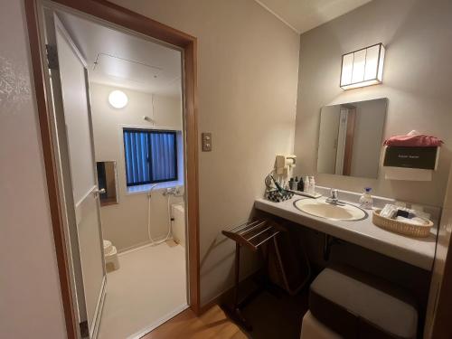 a bathroom with a sink and a shower and a mirror at 碧翠御苑 ゲストハウス風月庵 in Kyotango