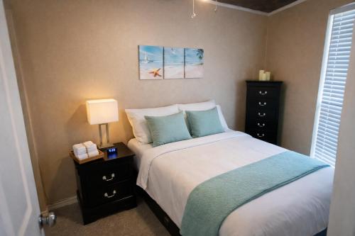 a bedroom with a bed and a night stand with a lamp at The Sandbar Stay - North Beach Waterfront Condo in Corpus Christi
