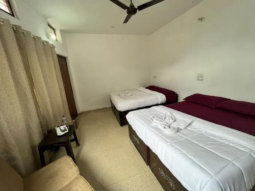 a room with two beds and a couch in it at Kedar Mount View in Sonprayag