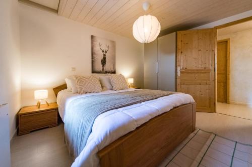 a bedroom with a large bed and a chandelier at Renovated Triplex House 8 guests Orelle in Orelle