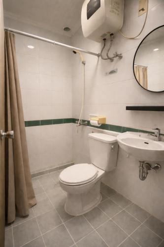 a bathroom with a toilet and a sink at Hotel Winotosastro Garden in Yogyakarta