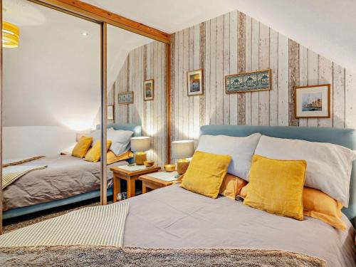 a bedroom with a mirror and a bed with yellow pillows at 1 Bed in Burntisland oc-47388 in Kinghorn