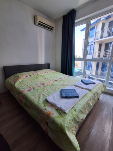 a bedroom with a bed and a large window at Студио C19 в к-с Blue Bay Palace in Pomorie