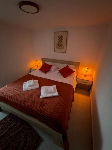 a bedroom with a bed with two towels on it at Apartmani ,,Merlin,, in Utjeha
