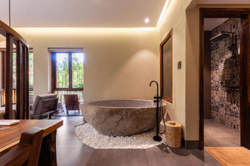 a large stone tub in the middle of a room at Sun Village Beach Resort in Tuy Hoa