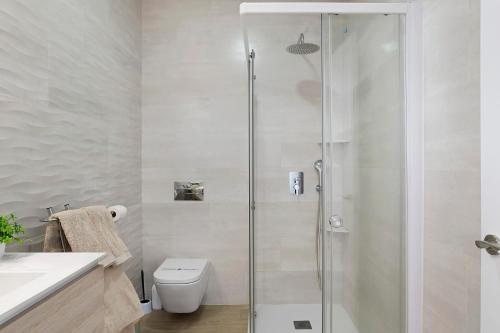 a bathroom with a shower with a toilet and a sink at Casas Las Arenas 2 in Conil de la Frontera