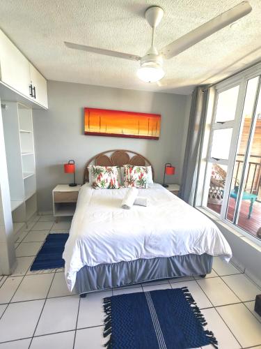 a bedroom with a large bed in a room with windows at OceanFront- Whale Watch- On Beach- Stunning in Umdloti