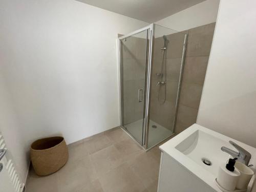 a white bathroom with a shower and a sink at Magnifique T3 full équipé, 100m de la plage et piscine N60 in Linguizzetta
