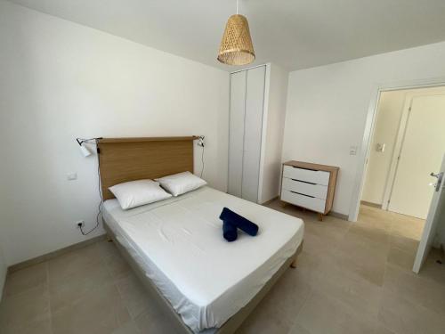 a bedroom with a large white bed with a blue object on it at Magnifique T3 full équipé, 100m de la plage et piscine N60 in Linguizzetta