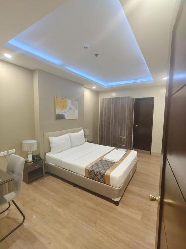 a bedroom with a bed with a blue ceiling at BEAVER HOTEL and RESIDENCES in Cebu City