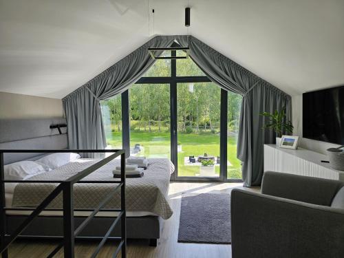 a bedroom with a bed and a large window at NOVA ULINIA Sea - dom nad morzem, podgrzewany basen, sauna, balia z jacuzzi,Starlink in Ulinia