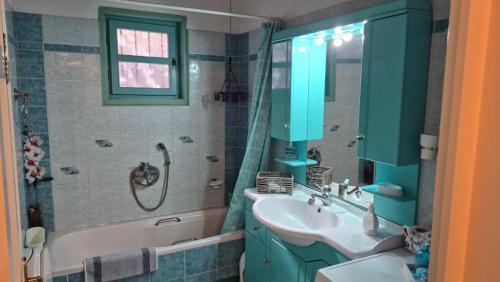 a bathroom with a sink and a bath tub and a sink at Βίλα Πασιθέα in Khánia
