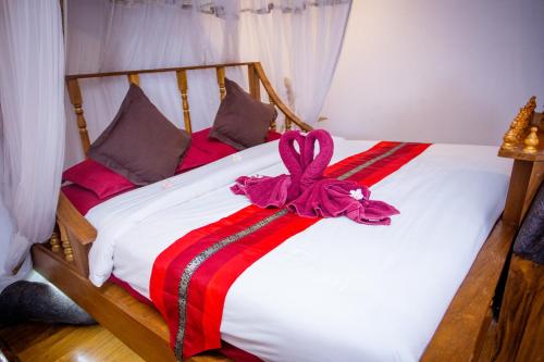 a white bed with a bow on top of it at Olivier Boutique in Chiang Mai