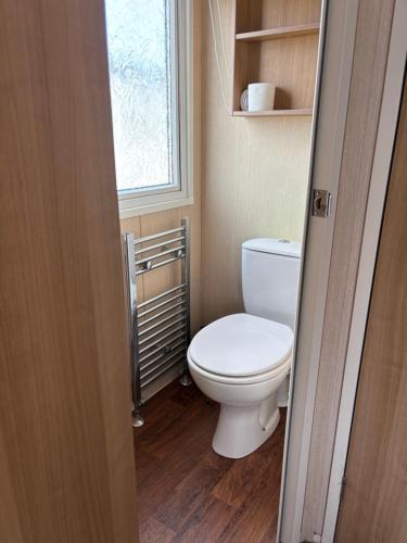 a small bathroom with a toilet and a window at Bobby's Bolthole in Heysham