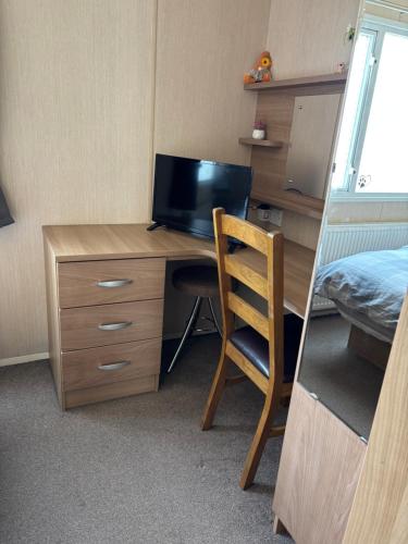 a room with a desk with a television and a chair at Bobby's Bolthole in Heysham