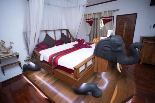 a bedroom with a bed with an elephant on it at Olivier Boutique in Chiang Mai
