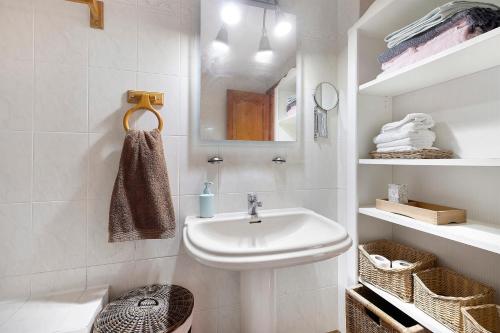 a white bathroom with a sink and a mirror at Casa Abril in L'Ampolla