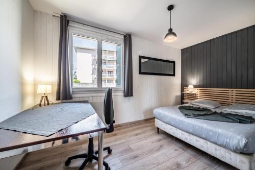 a bedroom with two beds and a desk and a window at Appartement Cosy Parc Thermal in Thonon-les-Bains