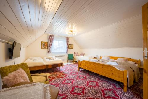 a room with two beds and a couch and a tv at Drevenička U Ježka in Ždiar