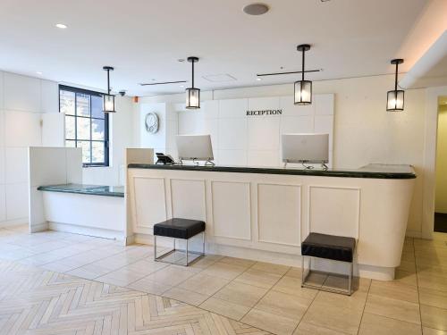 a lobby with a counter and two stools at THE DAY HOTEL ShinYokohama in Yokohama