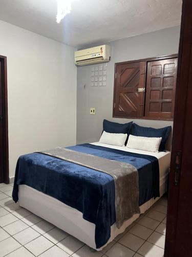 a bedroom with a bed with a blue blanket on it at É de casa unidade 01- JUAZEIRO DO NORTE in Juazeiro do Norte