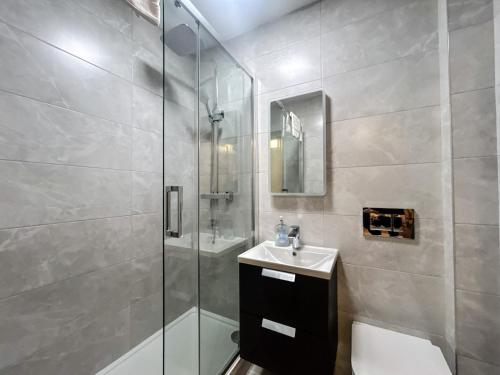 a bathroom with a shower and a toilet and a sink at Central Dingle Stay in Dingle