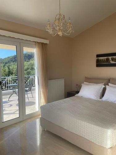 a bedroom with a bed and a balcony with a chandelier at Villa Fay in Preveza