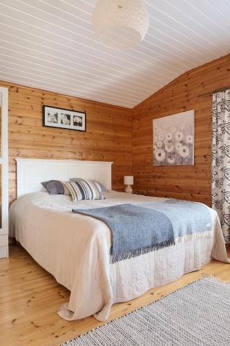 a bedroom with a large bed and wooden walls at Holiday Cabin Kukkula - AC, fireplace & wood-fired sauna in Porvoo