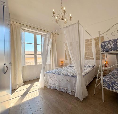 a bedroom with a canopy bed and a window at Al centro con panorama Favignana Isole Egadi in Favignana