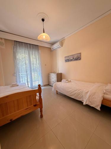 a bedroom with two beds and a window at Helios in Kavála