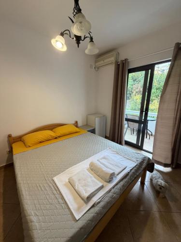 a bedroom with a bed with yellow pillows and a window at Apartments Regata in Ulcinj