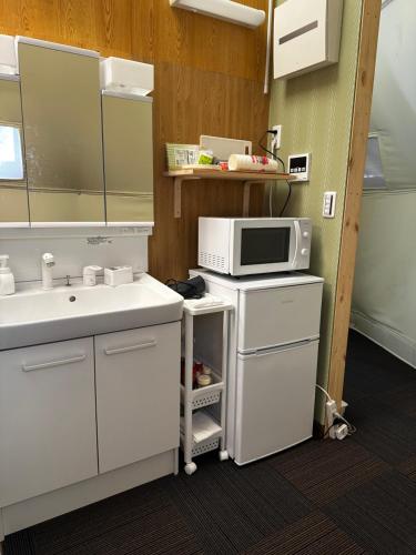 a kitchen with a sink and a microwave at 摩天轮下的森 in Tsumagoi