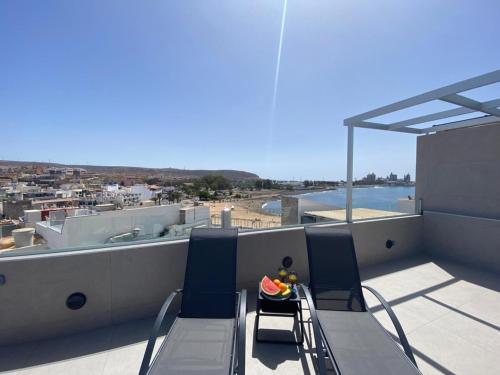 a balcony with a table and chairs on a roof at Alaram Holidays House by Villas Rivero in Arguineguín