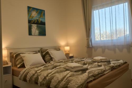 a bedroom with a large bed with a window at Netto Apartman in Fonyód